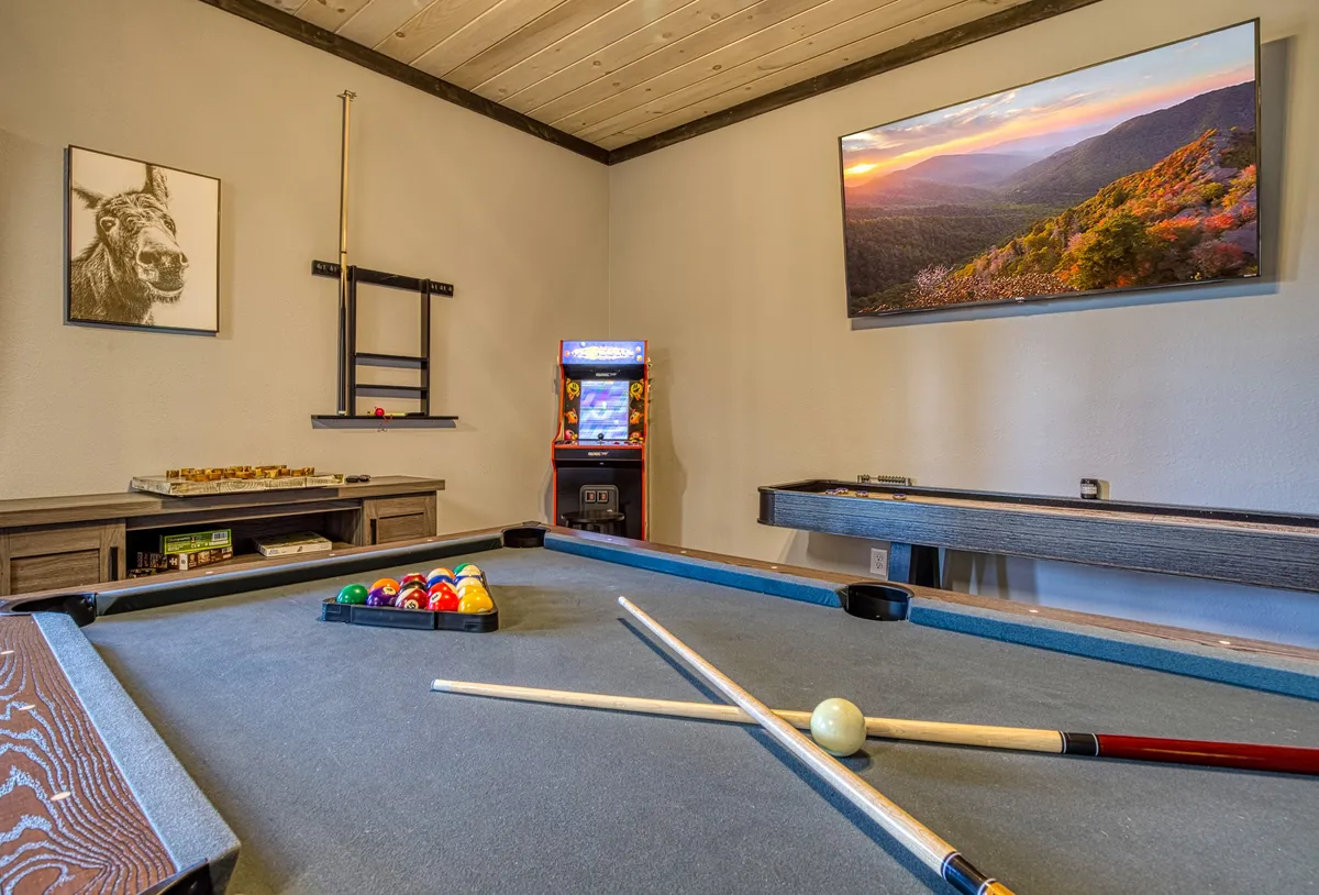 A vibrant media/game room with a pool table, arcade machine, and comfortable seating, inviting families to gather for games and entertainment after a day of exploring.